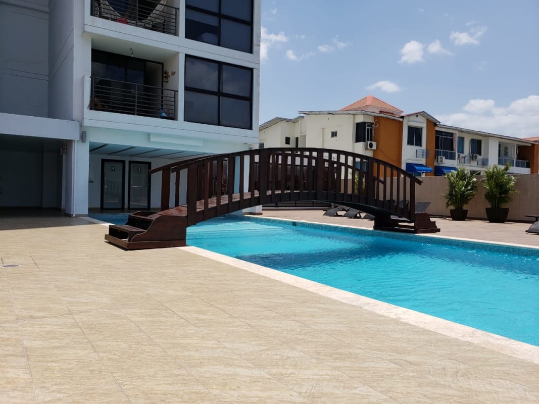 Modern tall residential tower exterior of PH Vista Verde with blue pool in foreground in Panama City