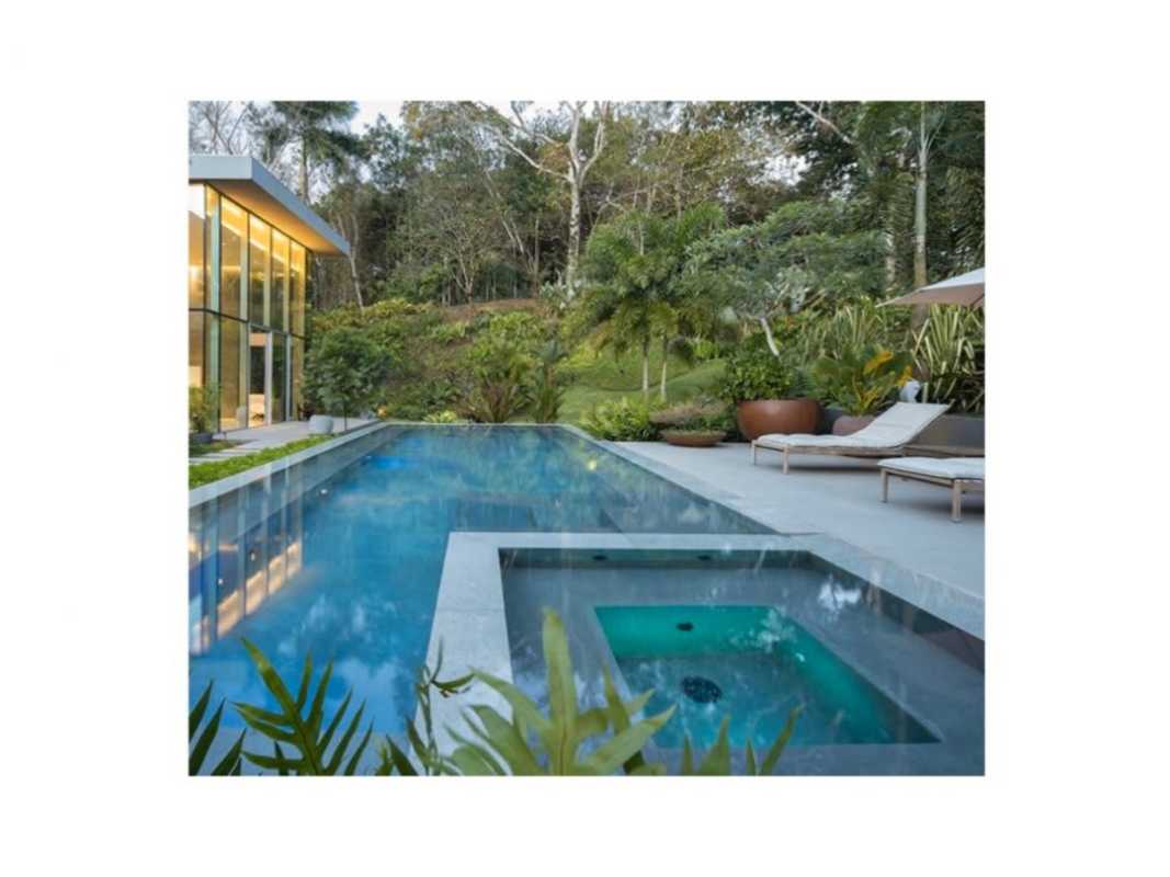 Luxury house with large windows and garden lit up at night in Panama