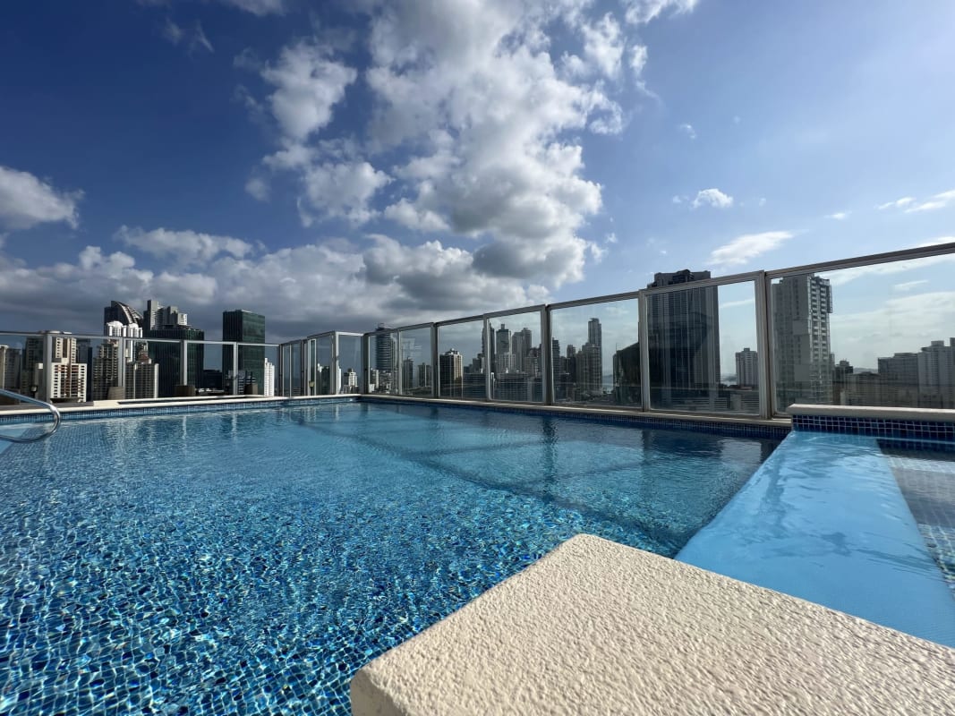 Spacious living room with large windows, ceiling fan, city skyline view PH The One Obarrio Panama City