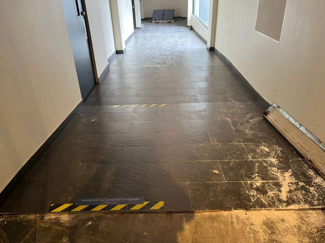 Interior commercial hallway dark slate tile windows caution tape under renovation Victoriano Lorenzo Panama