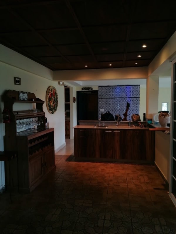 Traditional bedroom with wood ceiling, large window overlooking gardens in Cerro Azul Panama mountain house