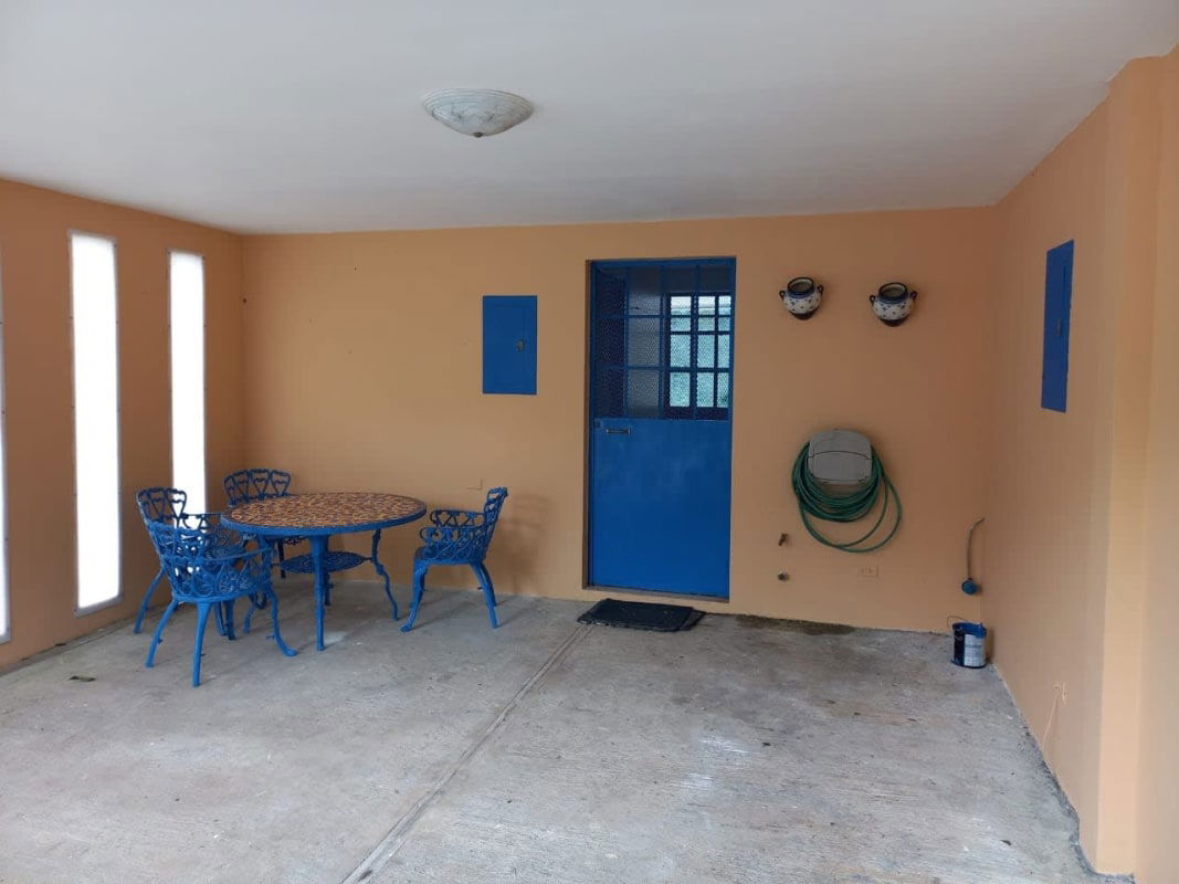 Rustic kitchen with central island, wood cabinetry, tile backsplash in Cerro Azul mountain house Panama
