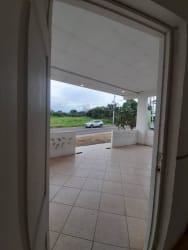 Covered porch area tiled with view of greenery in backyard house in Monagrillo Chitré Panama