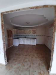 Tiled L-shaped kitchen with traditional cabinets and recessed lighting in house for sale Chitré Panama