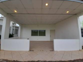 Covered outdoor patio with tiles, lighting, half wall in suburban house Chitré Panama