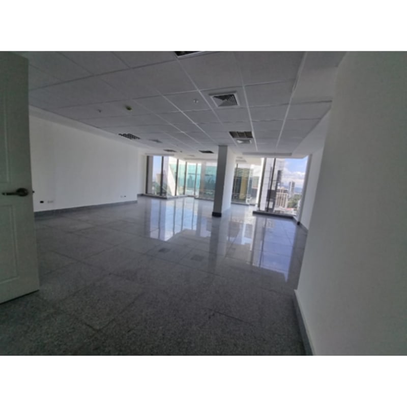 Modern commercial office interior with suspended ceiling tile flooring and city light at Twist Offices Obarrio Panama