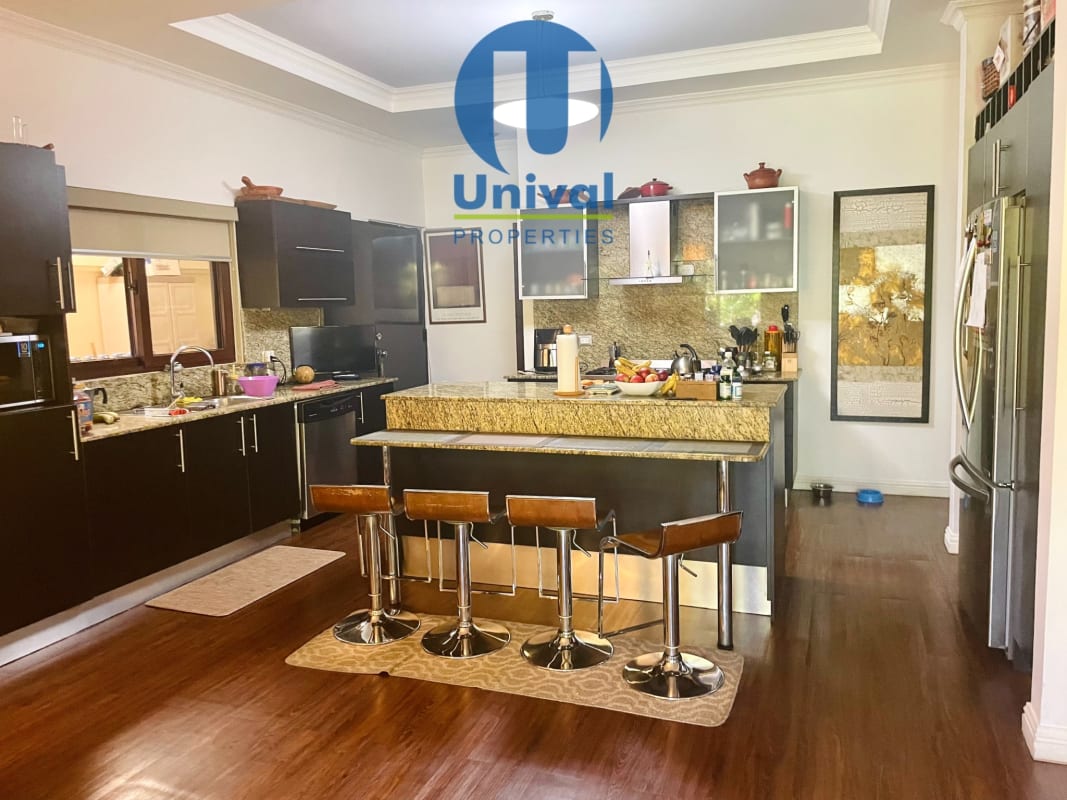 Modern open kitchen island with granite countertops Costa Sur luxury home for sale