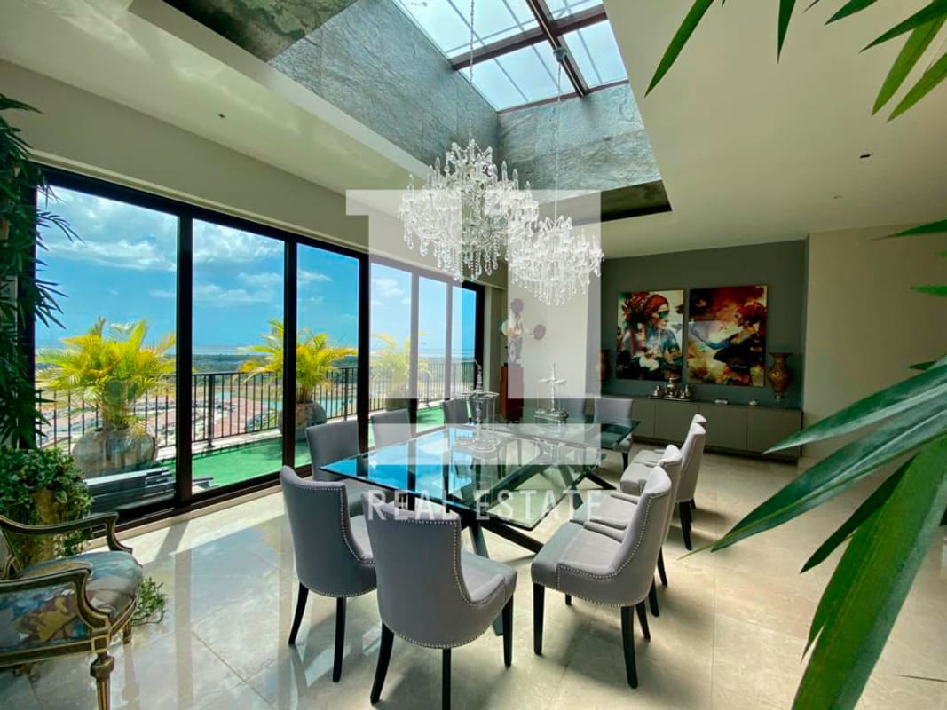 Modern dining room with chandelier, marble floors, large windows overlooking balcony and Santa Maria golf