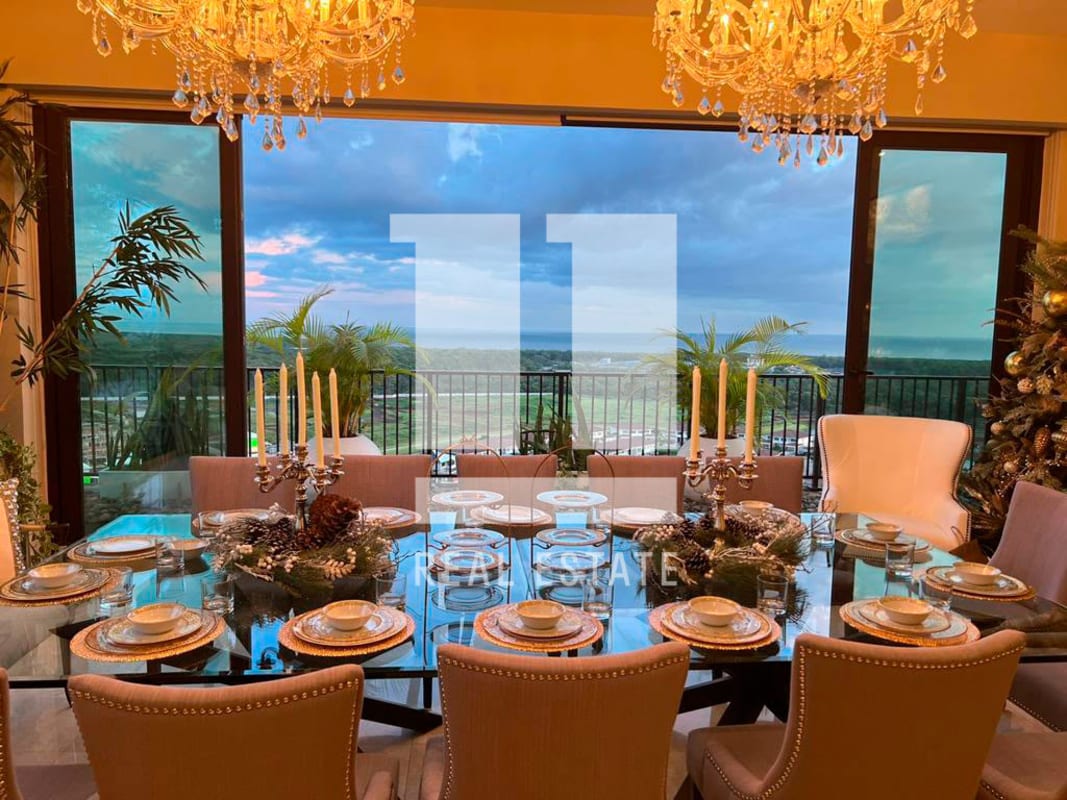 Luxury dining room with glass table, chandeliers, floor-to-ceiling windows and golf course views