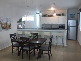 Bright open kitchen and dining space with appliances at Playa Blanca Panama