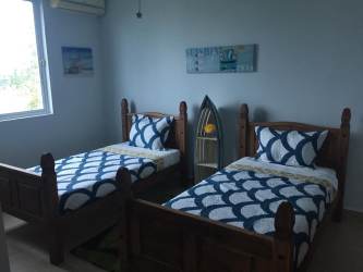 Coastal-themed bedroom with twin beds and AC at PH Terrazas Villas Playa Blanca Panama