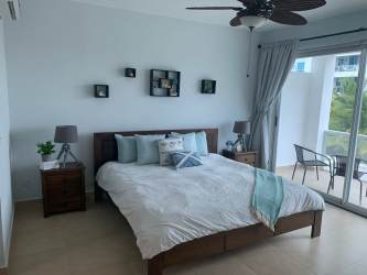 Bedroom with glass doors to balcony and ocean views at Playa Blanca Condo Panama