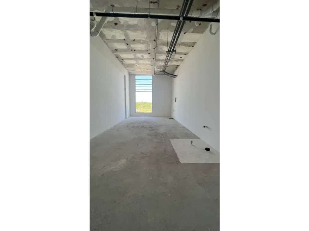 Interior unfinished clinic room exposed ceiling concrete floors large window in Panama
