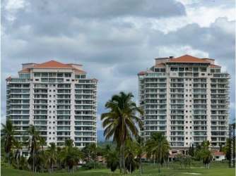 Two modern towers with balconies and lush landscaping at Vista Mar Golf & Beach Resort.