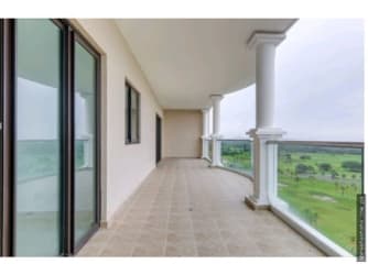 Spacious covered balcony with glass railing, panoramic Pacific Ocean and green mountains vistas in Vista Mar Resort.