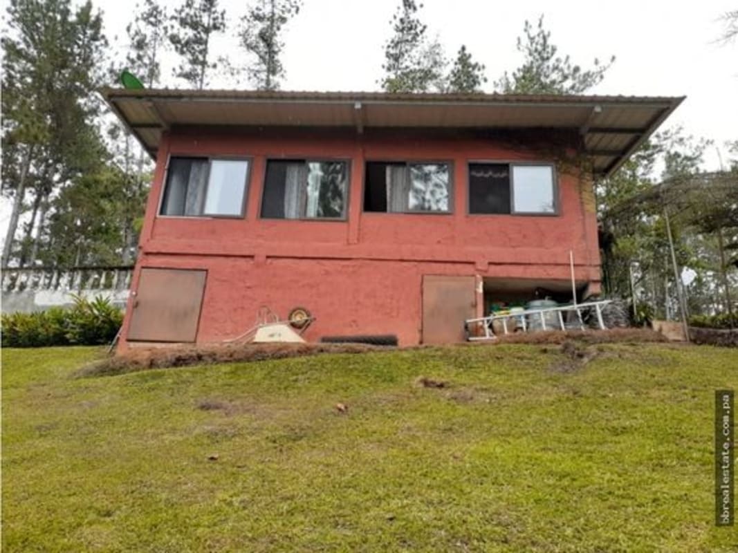 Rustic bedroom with wooden beams, large windows, cozy decor in Cerro Azul mountain community Panama