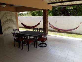 Outdoor bohío area with hammocks and bar at Costa Esmeralda beach residence Panama