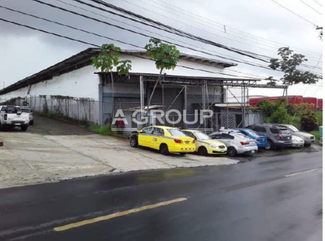 Facade of industrial warehouse with parked vehicles along fence Avenida Fernández de Córdoba Panama City