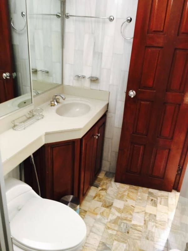 Traditional bathroom with wood vanity, marble tile floor at PH BICSA Panama City