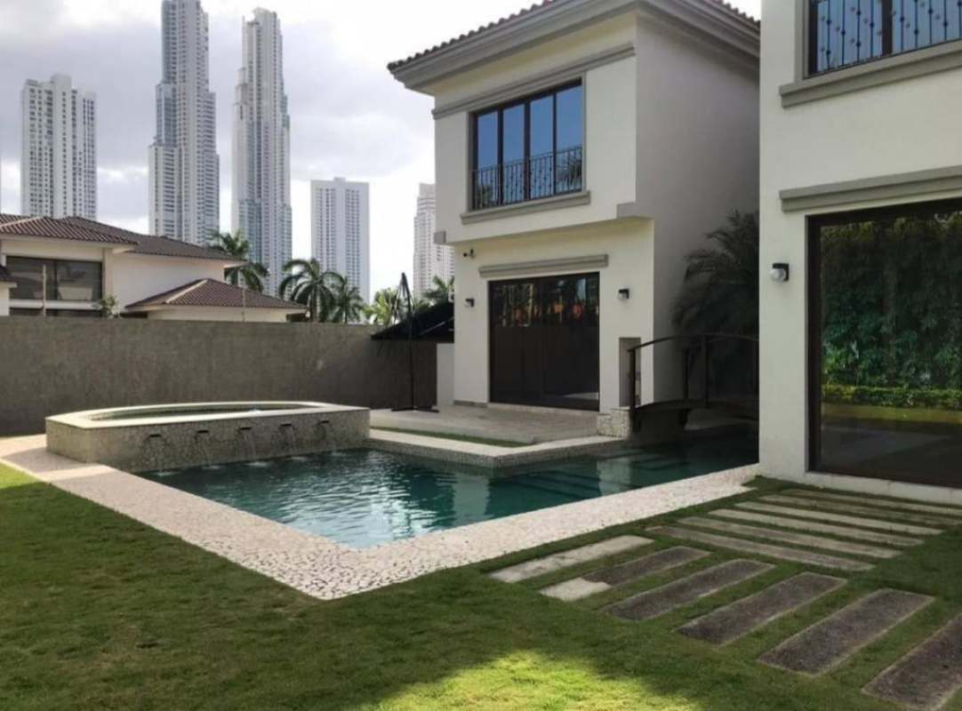 Elegant curved staircase with ornate railing and marble floors in luxury 3-story home in Costa del Este