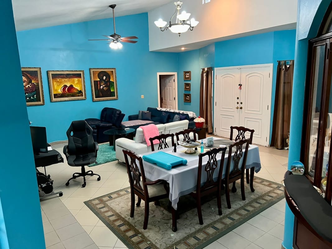 Bright living and dining space with blue accent walls traditional house Las Cumbres