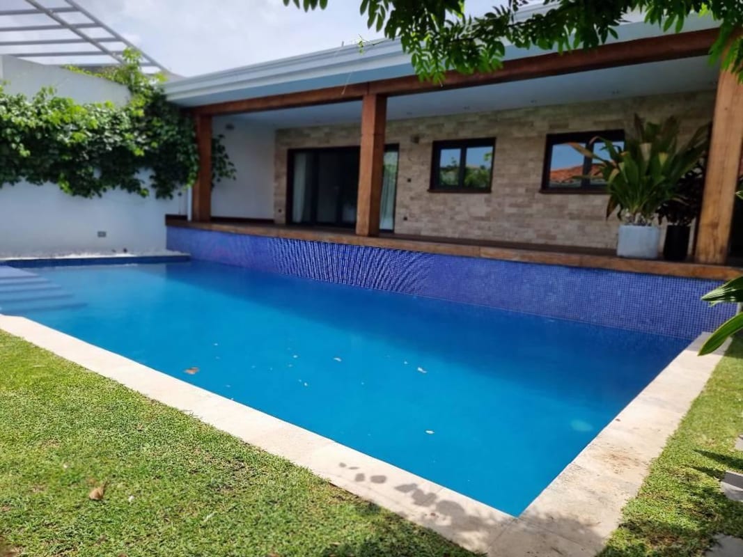 Swimming pool with stone patio surrounded by tropical gardens in Brisas del Golf Panama