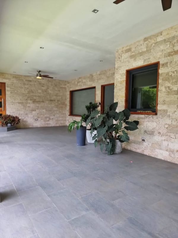 Contemporary bathroom with pedestal sink, tiled walls, and large mirror in luxury home Panama
