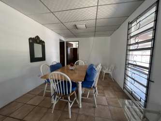 Swimming pool overlooking garden and covered patio area at Coronado Beach house in Panama
