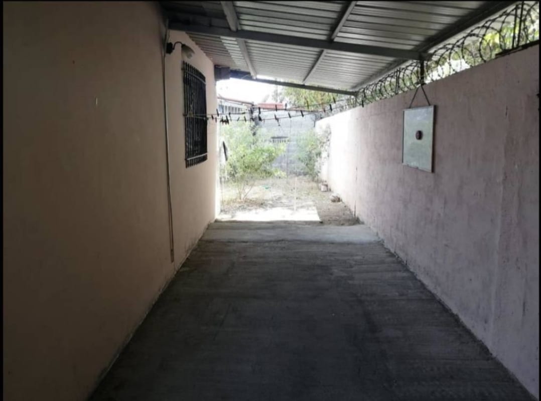 Front exterior with covered gated carport, security features and garden area in Villa Belén Tocumen Panama