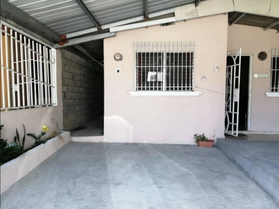 Covered back patio with concrete floor and small garden space in Villa Belén Tocumen