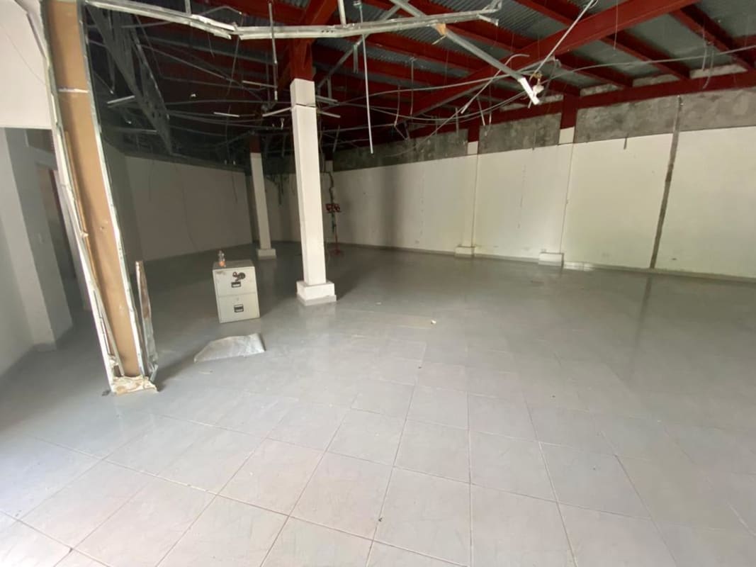 Unfinished large open interior with exposed beams, tiled floor and columns, Albrook Panama