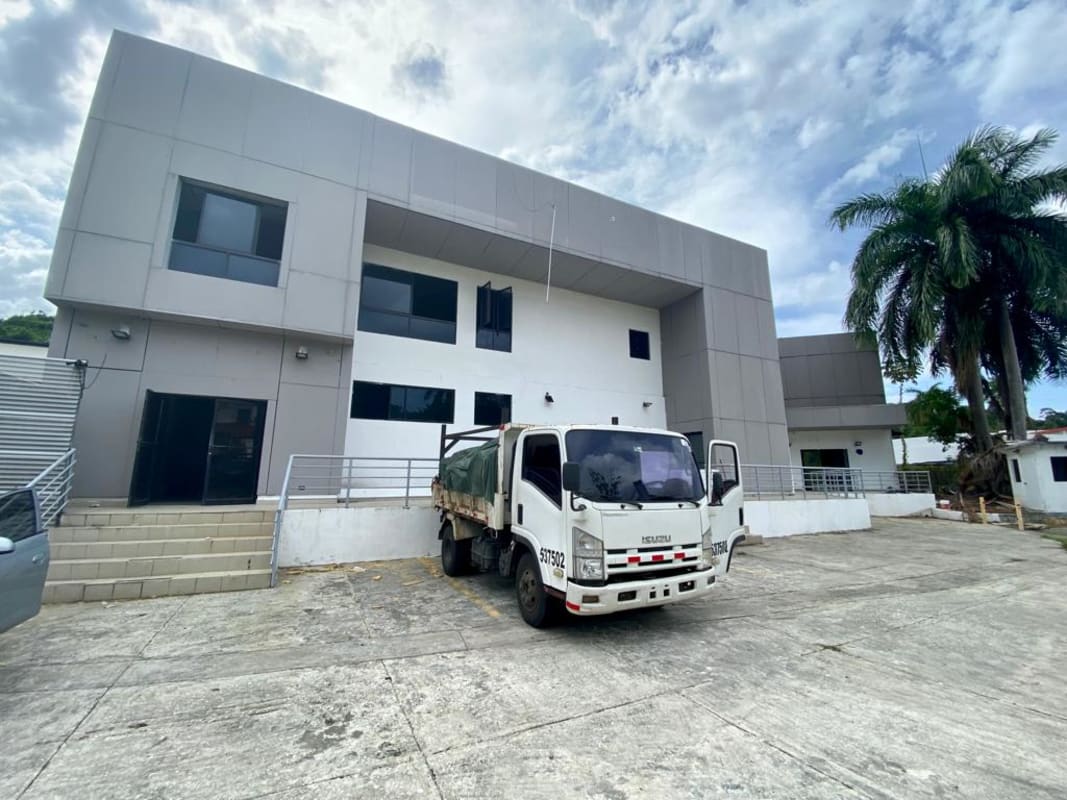 Two-story modern commercial building facade and parking Albrook Panama