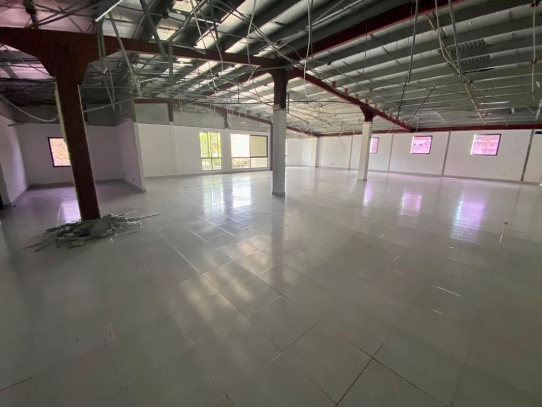 Empty open industrial space with tiled floor, steel beams, natural lighting in Albrook