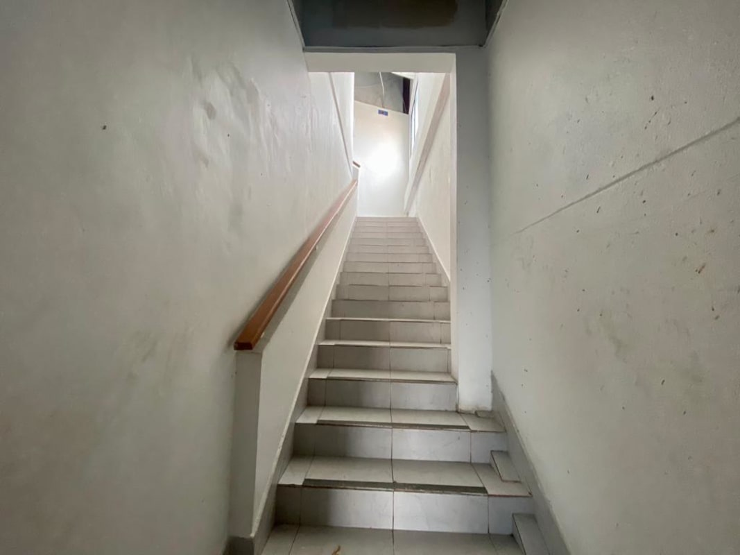 Indoor staircase white walls tiled steps leading to upper business floor Albrook Panama