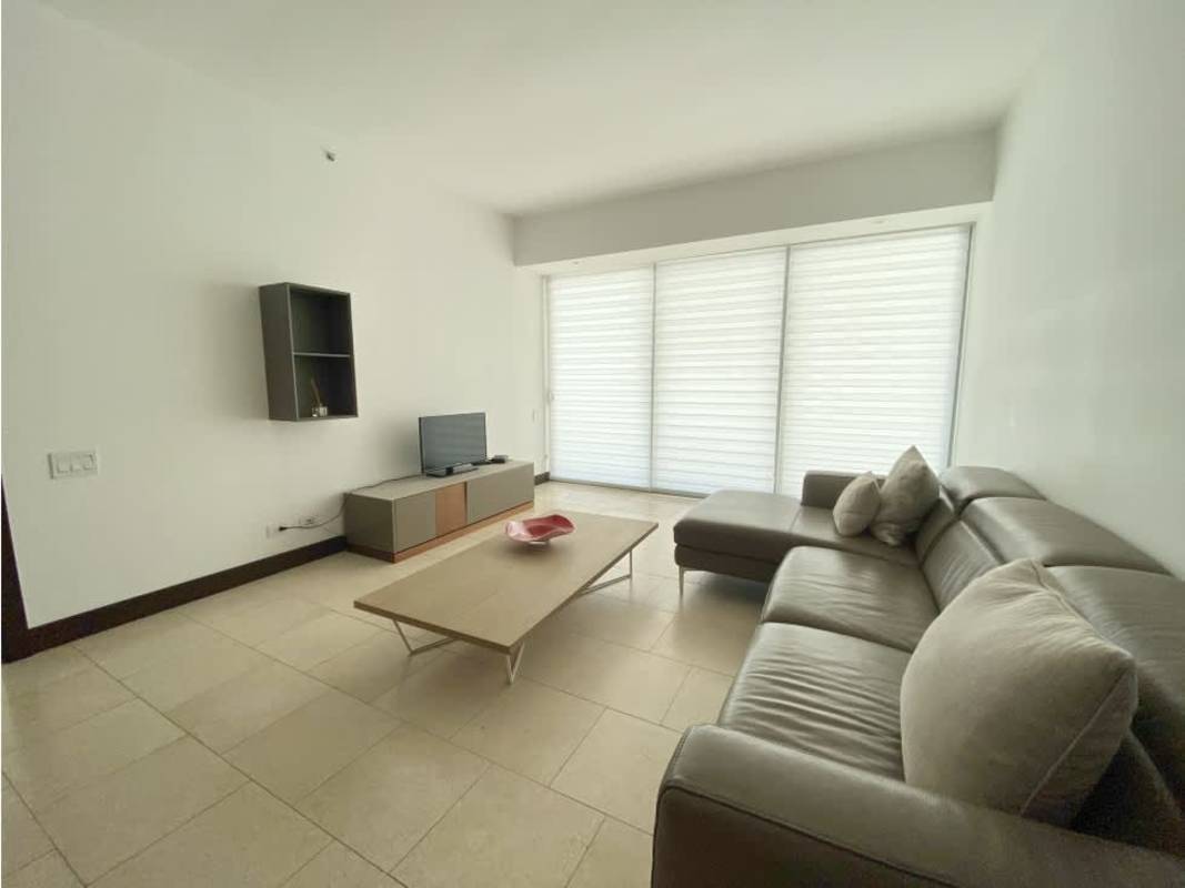 Bright minimalist living room with sectional sofa, floor-to-ceiling windows at The Ocean Club Punta Pacifica Panama