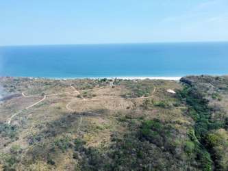 Wide aerial shot of oceanfront terrain bordered by Coton river with beach waves in San Carlos Panama