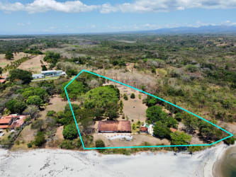 Titled beachfront estate with sandy shoreline and coconut trees in Chumico Panama