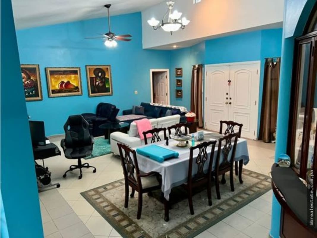 Bright open-plan living dining space with blue walls and elegant furnishings in Las Cumbres Panama