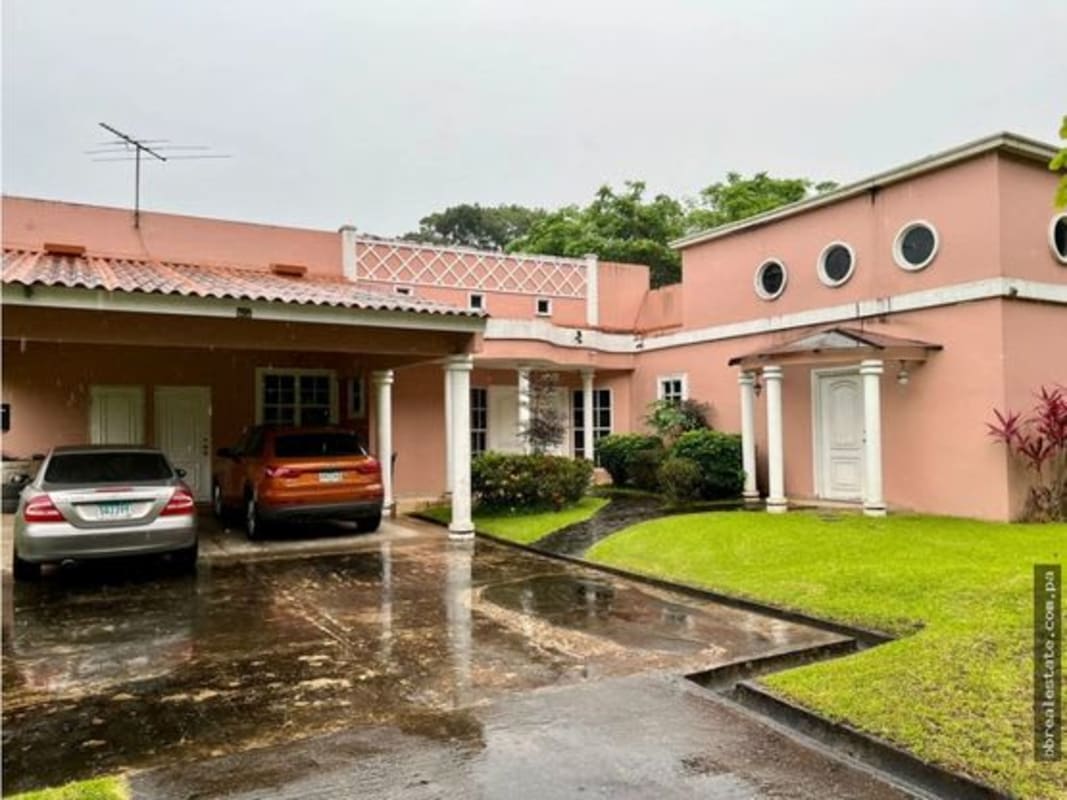 Pink Mediterranean house with white pillars, carport and garden in Las Cumbres Panama