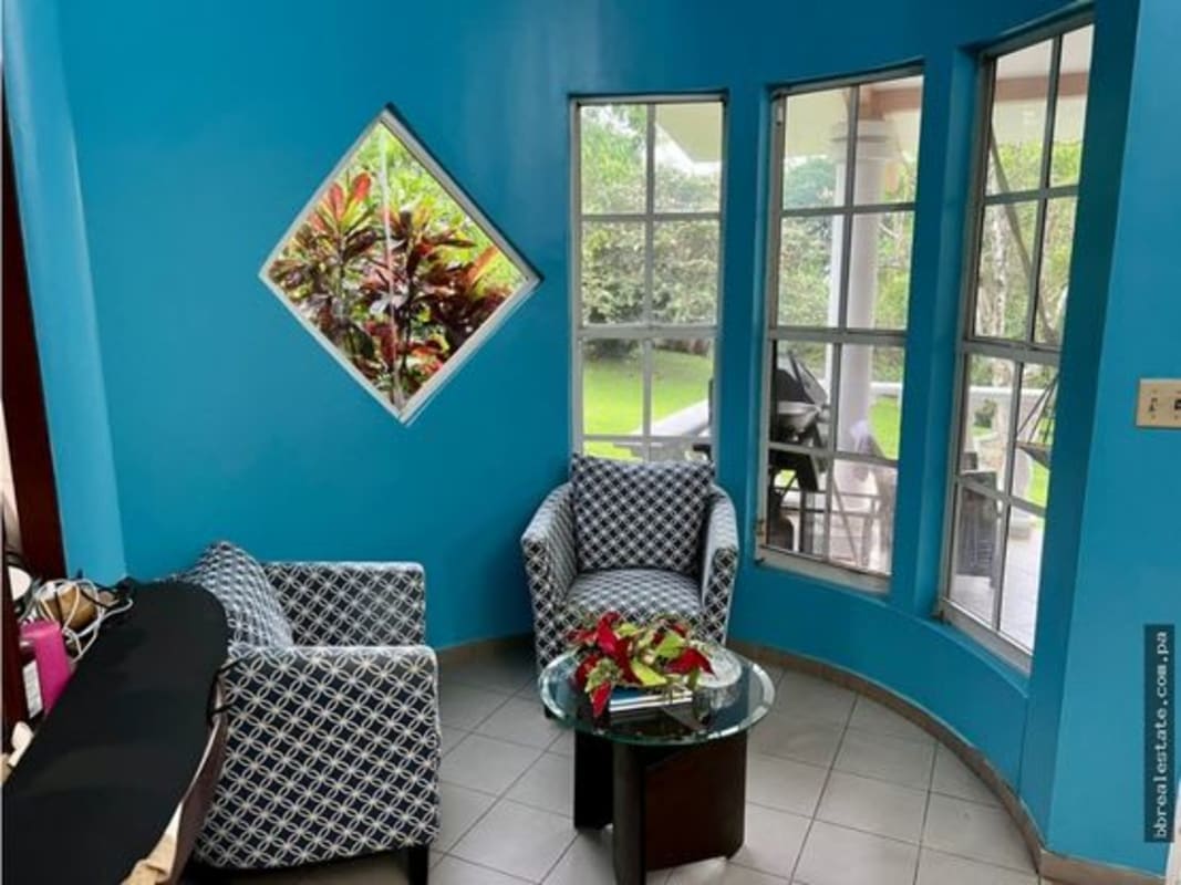 Bright sitting room with bay windows and garden view Las Cumbres house Panama