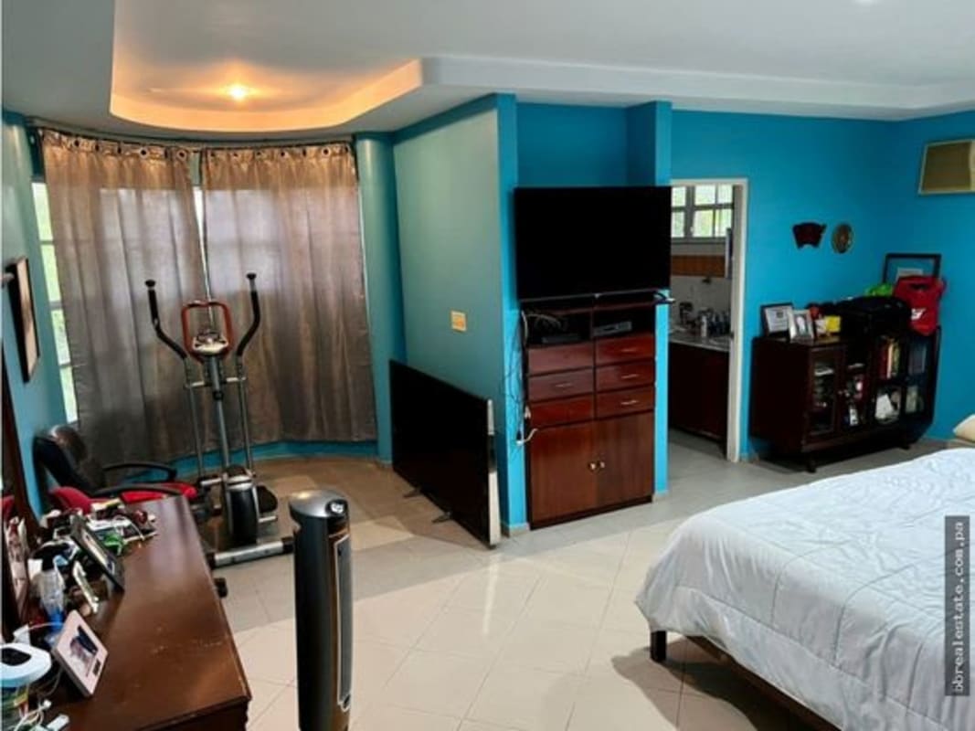 Large master bedroom with blue walls, workspace, bedroom furniture, Las Cumbres family house Panama