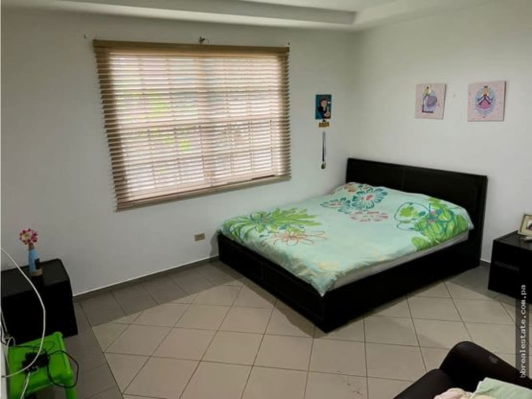 Modern bedroom with large window and floral bedding Las Cumbres Panama home