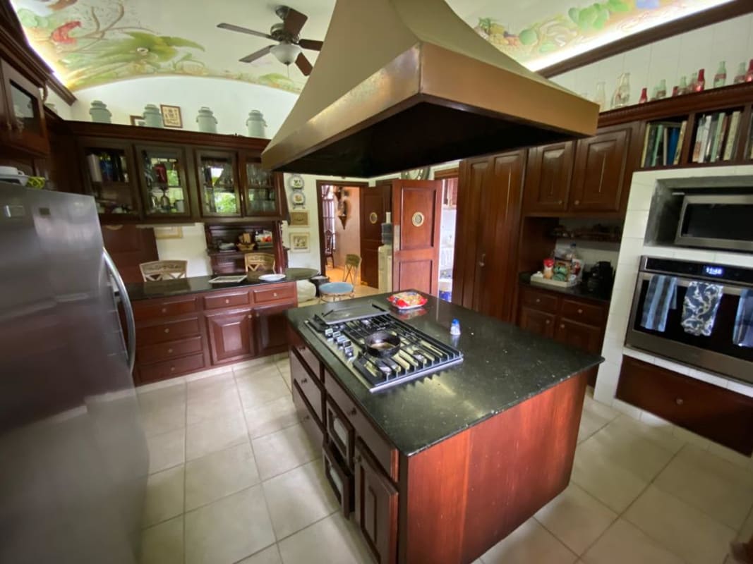 Elegant living room with cream sectional sofa, large windows, artwork in Altos de Golf mansion Panama City