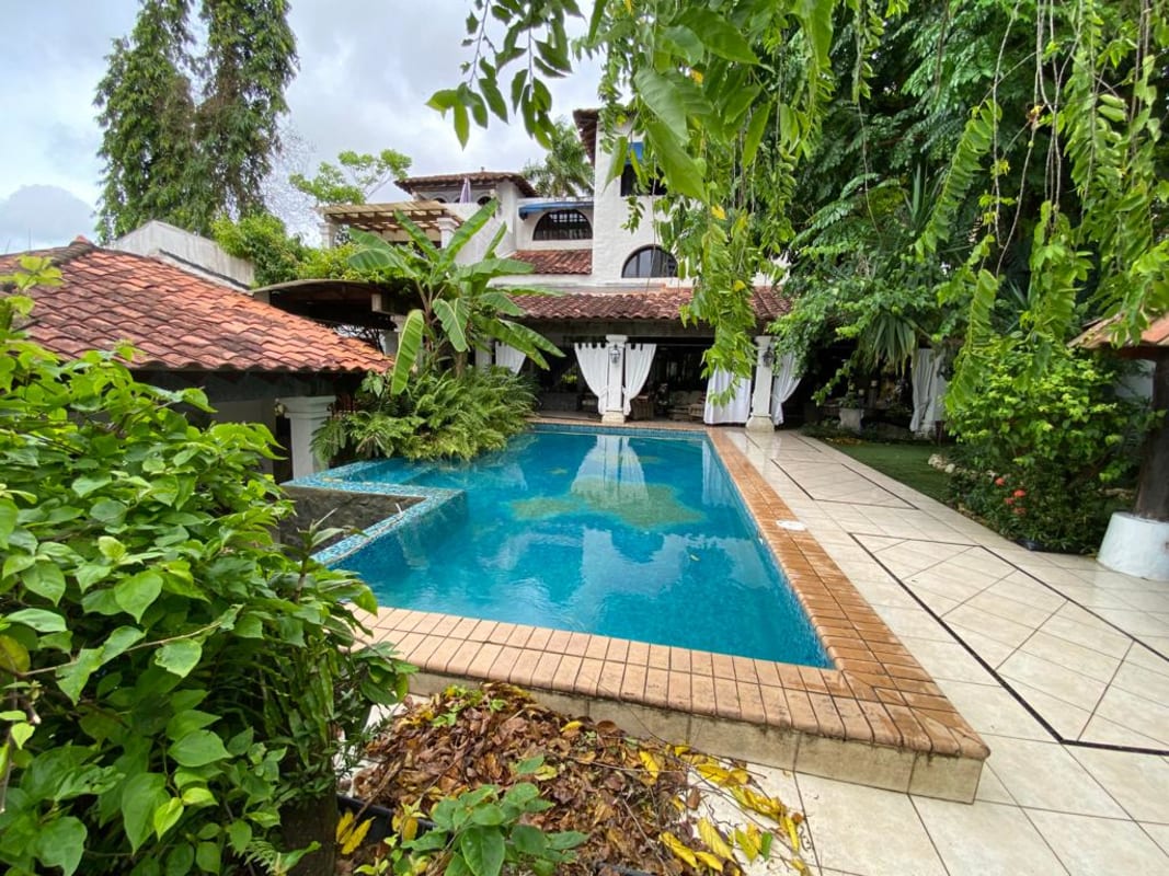 Mediterranean style luxury home pool surrounded by tropical garden in Altos de Golf residence Panama City