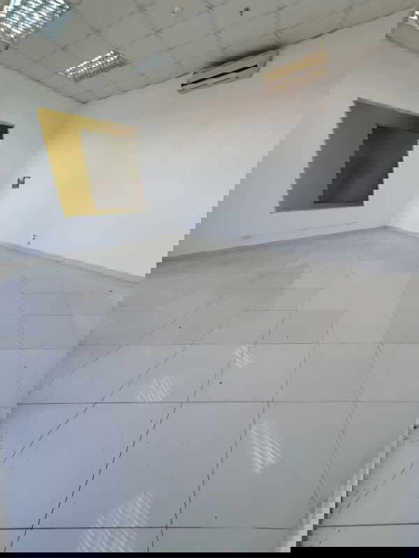 Empty tiled commercial unit with large yellow-trimmed window in Plaza Tocumen Panama