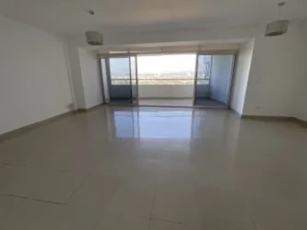 Bright living area with glass doors to balcony overlooking skyline in PH Elevation Costa del Este