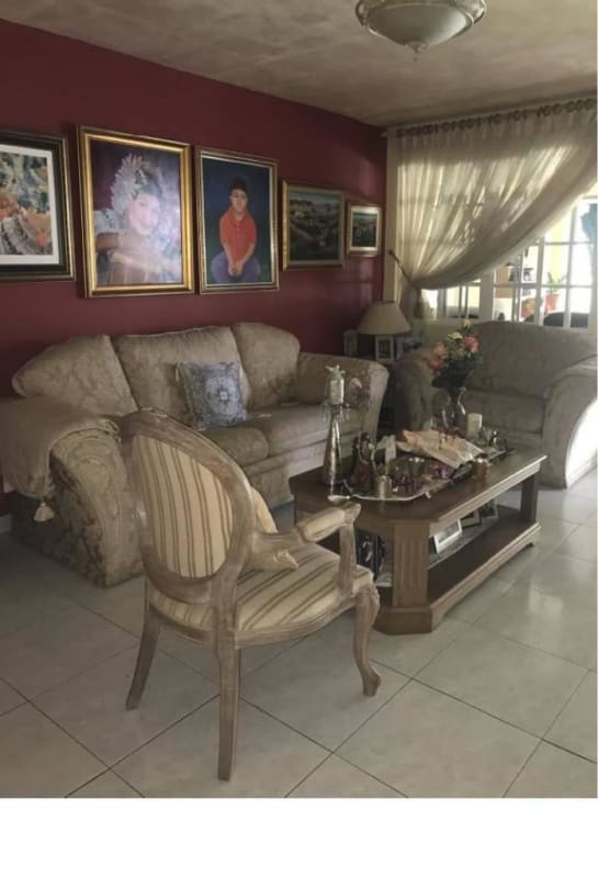 Spacious living area with red accent wall, beige sofa, large windows at Green Valley residence Albrook Panama
