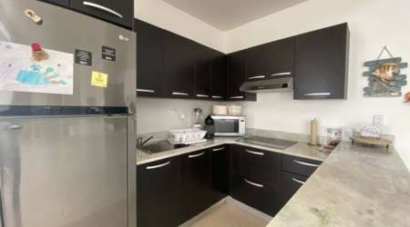 Spacious minimalist kitchen with breakfast bar and dining area fully furnished at Ibiza Beach Residences Panama