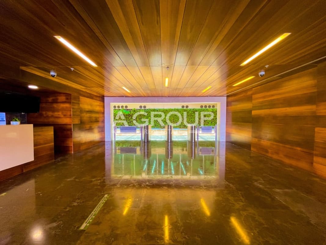 Luxurious office lobby with wood walls, turnstile access and green wall in Torre Argos Santa Maria Panama