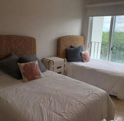 Bright bedroom with balcony access overlooking gardens in Buenaventura luxury condo Panama